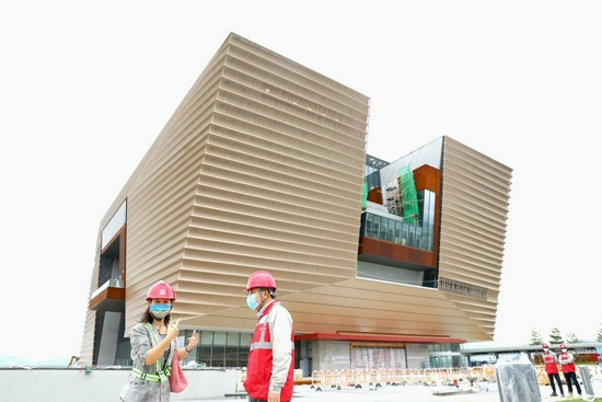 记者在即将竣工的香港故宫前采访中国建筑国际集团有限公司香港故宫项目负责人王勇（右）（10月22日摄）。新华社记者 吴晓初 摄
