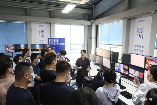 山东港口日照港集装箱发展有限公司日新自动化运营中心自动化轨道吊负责人李艺萱向“港口雄开万里流”网络主题采访团记者详细介绍自动化轨道吊运行情况。（摄影记者 修泽旭）