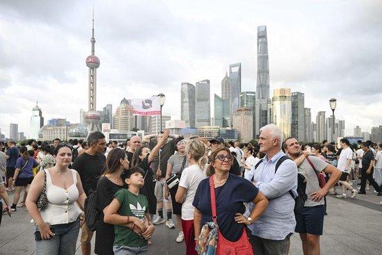 2025年7月21日,意大利游客在上海外滩听导游介绍景点。新华社记者 陈浩明 摄