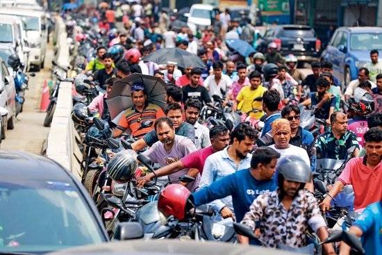 4月18日，孟加拉国首都达卡，在加油站外排队等待加油的人群。