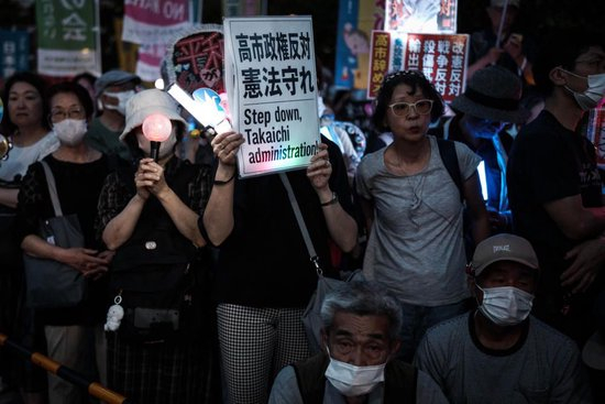  5月19日，在位于日本东京的国会议事堂前，民众手持标语参加集会，抗议高市政府破坏和平宪法。新华社记者贾浩成摄