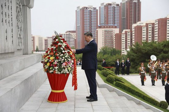 6月9日上午，正在朝鲜进行国事访问的中共中央总书记、国家主席习近平和夫人彭丽媛参谒中朝友谊塔。朝鲜劳动党总书记、国务委员长金正恩和夫人李雪主陪同。这是习近平整理花篮缎带。新华社记者 丁海涛 摄