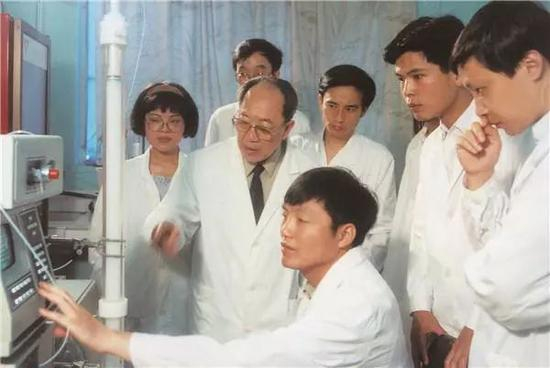 ·吴孟超指导学生手术器械操作。