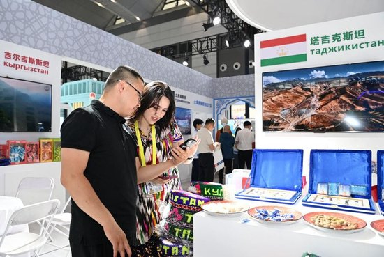 △2025年5月21日，在第九届丝绸之路国际博览会暨中国东西部合作与投资贸易洽谈会丝路优品展上，参观者了解塔吉克斯坦商品。