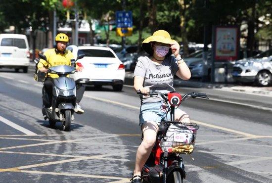 6月24日，河北省石家庄，市民在高温下全副武装骑车前行。图/中新图片网