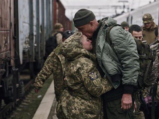 当地时间2023年3月29日，顿涅茨克地区克拉马托尔斯克，一名即将去前线的乌克兰女兵在火车站与丈夫分别。