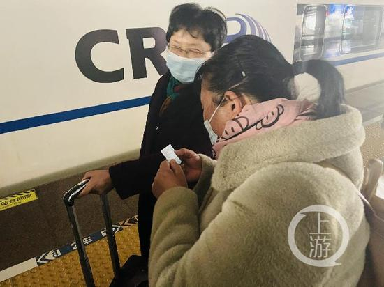 　　▲12月20日，受害者“小木匠”妻子朱大红在合肥准备前往南昌参加庭审。上车前她和律师仔细核对车票信息。摄影/上游新闻记者 时婷婷