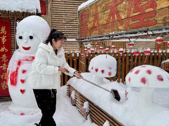 史瑞娟在整理民宿院里的冰雪雕塑（央广网记者马俊玮 摄）