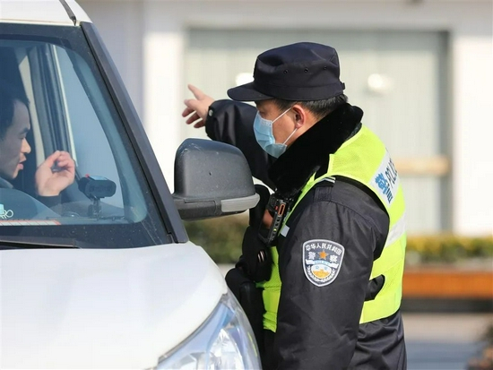  △南翔所民警在白鹤息园出口道路进行交通管制，指引车辆通行。