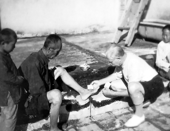 正在贝家花园内给村民治病的贝熙叶