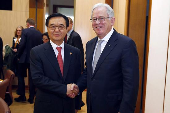  2015年6月17日，高虎城和罗布在中澳自贸协定签署后握手 