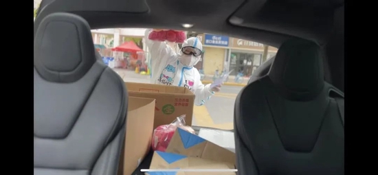  ▲何艳君清点放在车上的物资，封控后她和丈夫加入了义务配送队。受访者供图