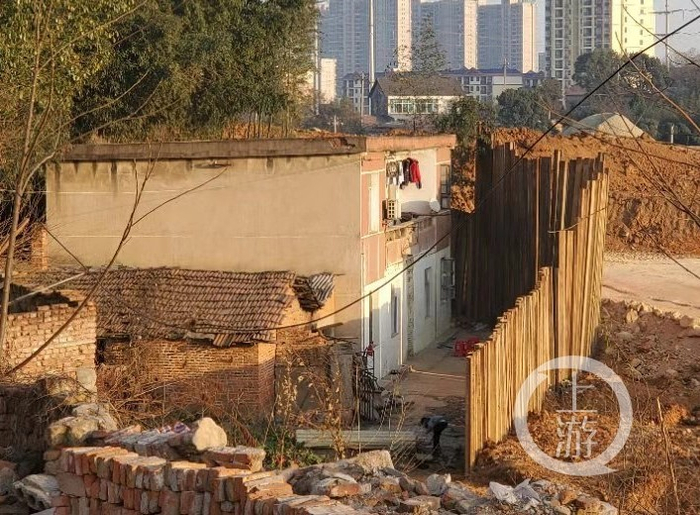 ▲2021年1月下旬，李开棚、谷凤华家的房子被高高的竖状铁条包围，房外是岳阳市北二环线重点工程。摄影/上游新闻记者 肖鹏