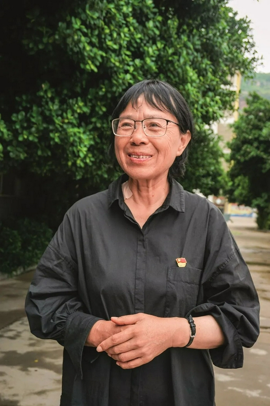 　　2020年7月，张桂梅在云南丽江接受记者采访。图为她看着女高教学楼，露出微笑。（本刊记者 陈霖/摄）