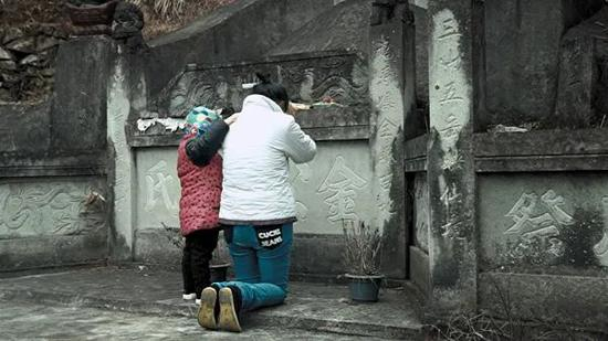 金立芬在父亲的坟前。