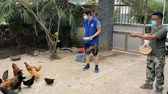  毕鹏和胡强在村民家里帮忙喂鸡
