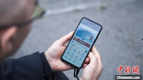  图为重庆市民使用电子社保卡办理业务。　陈鑫 摄