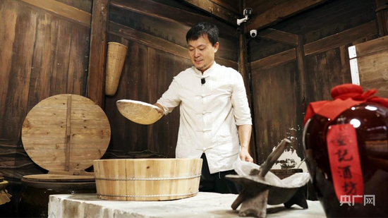  查永红向游客展示酿酒技艺（央广网记者 郇康新 摄）