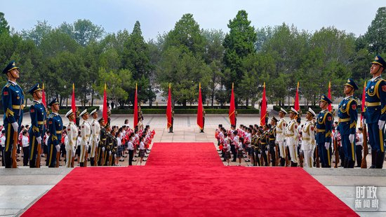 △人民大会堂北门外，红毯铺就、红旗飘扬，礼兵列队、少年儿童手持花束迎候“七一勋章”获得者。（总台央视记者胡玮拍摄）