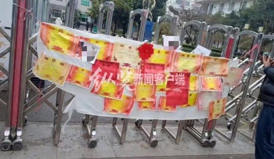 网传视频中家属在学校门口挂的身亡学生的奖状&nbsp; （来源/视频截图）