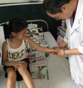  2008年，汶川地震后，成都中医药大学附属医院的志愿者记录医生为被救女孩治疗。受访者供图