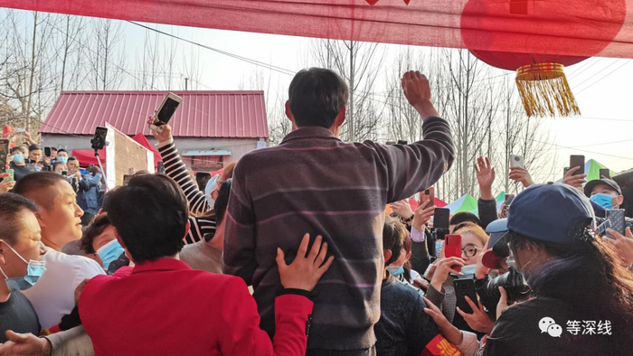 程运付被几人扶着腰，站在板凳上跟主播问候。&nbsp;《等深线》记者 郑丹 摄