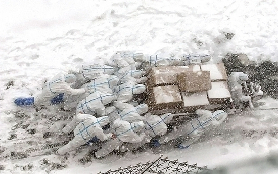 大连海洋大学的志愿者推着满载的三轮车上坡，将物资送到学生宿舍（2021年1月6日摄）。新华社发（大连海洋大学供图）