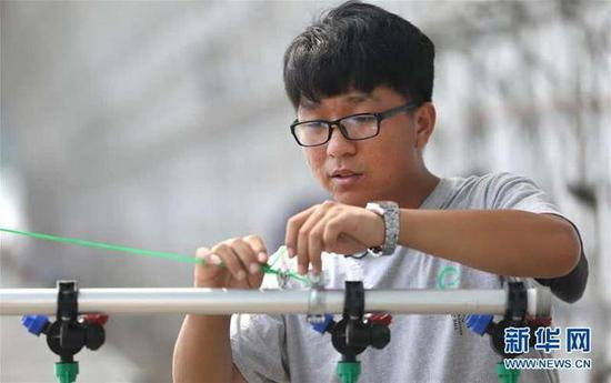 盘锦市大洼区的郭佳明在自家的蔬菜种植大棚里调试设备（7月16日摄）。新华社记者 姚剑锋 摄