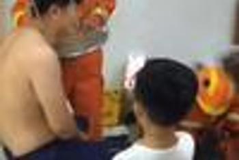 男子头卡凳子 儿子用手机记录