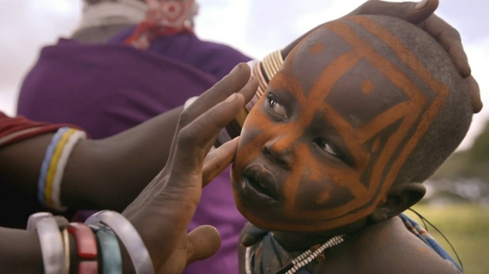 非洲的马赛人在部落仪式前正往孩子的脸上涂抹红赭石颜料（图片来源：知乎-纪客视界）