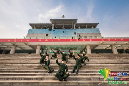 学员们坐在主教学楼石阶上，背后是习近平总书记提出的“对党忠诚、服务人民、执法公正、纪律严明”的十六字总要求，毕业学员们形成一个心的图案，并把军帽扬向天空，表明了坚决贯彻落实主席要求的决心。中国青年网通讯员 褚龙 摄