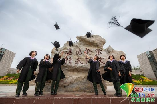 毕业女学员的背后是我院校训石，她们把学士帽奋力抛洒，表明了自己的自信与昂扬，必将牢记校训精神，始终不忘初心，牢记使命，进德修业，精武博文，不辱使命。中国青年网通讯员 褚龙 摄