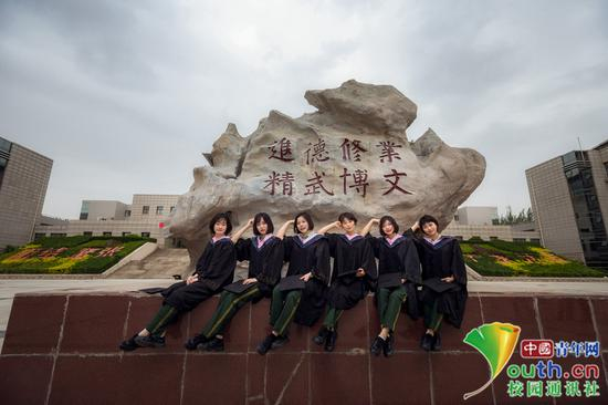 &nbsp;毕业女学员的背后是我院校训石，她们将牢记校训精神，始终不忘初心，牢记使命，进德修业，精武博文，不辱使命。中国青年网通讯员 褚龙 摄