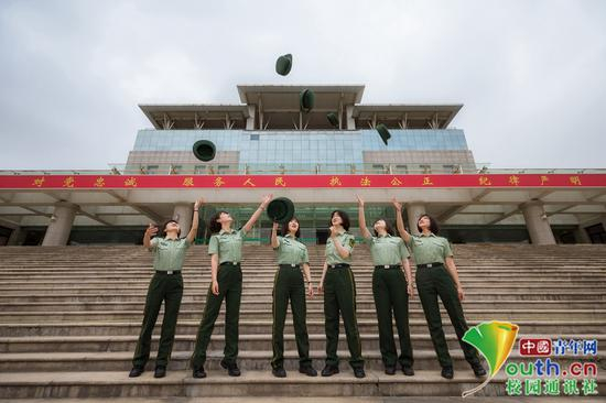 女学员们站立在主教学楼石阶上，背后是习近平总书记提出的“对党忠诚、服务人民、执法公正、纪律严明”的十六字总要求，形成为前一个人戴帽子的动作，表明了整理行装再出发的意气风发。中国青年网通讯员 褚龙 摄