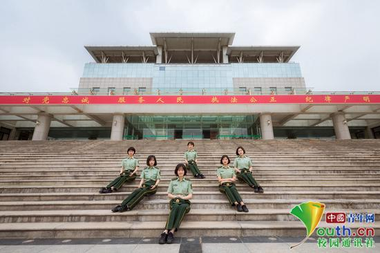女学员们端坐在主教学楼石阶上，背后是习近平总书记提出的“对党忠诚、服务人民、执法公正、纪律严明”的十六字总要求，体现军校女学员的端庄、知性，矢志不渝。中国青年网通讯员 褚龙 摄