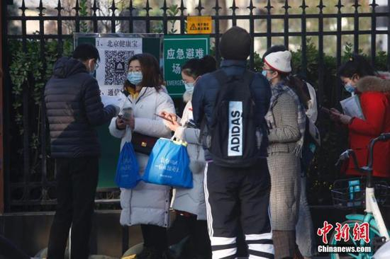 资料图：2020年11月29日，北京市东城区一处国考考点外，考生排队等候入场。中新社记者 蒋启明 摄