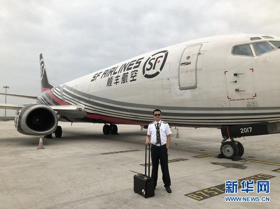 汪勤金和他惯于驾驶的波音737-400型飞机。新华网发（李夏摄）