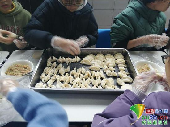 图为同学们正在包饺子。中国青年网通讯员 宋光雯 摄