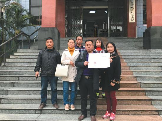 　　昨日，该案宣判后，几名被拐幼儿的家长拿着判决书在法院门口合影。 &nbsp;&nbsp;&nbsp;&nbsp;受访者供图