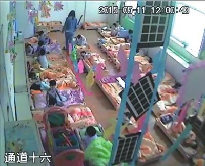 涉案幼师手拿棍状物打孩子。视频截图
