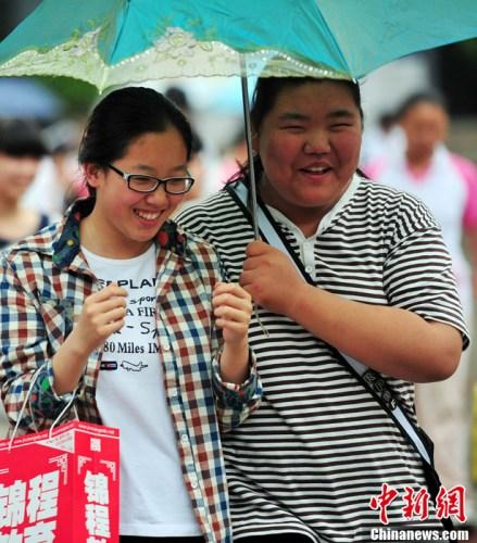资料图：2013年7月1日，在沈阳第134中学考点，考生考试结束后走出考场。当日上午是沈阳中考的最后一上午考试，沈阳阵雨转大雨。<a  href='http://www.chinanews.com/'>中新社</a>发 于海洋 摄