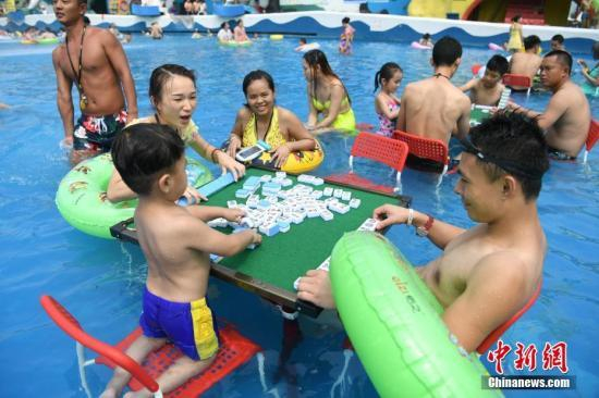 资料图：重庆洋人街一水上乐园举行夏季消暑活动，其中水中玩麻将吸引不少游客参与。陈超 摄