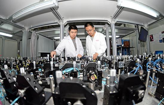 2017年4月20日，安徽合肥，在中国科大多光子纠缠实验室，黄合良（左）和罗弋涵正在进行量子计算和量子实验。 东方IC 图