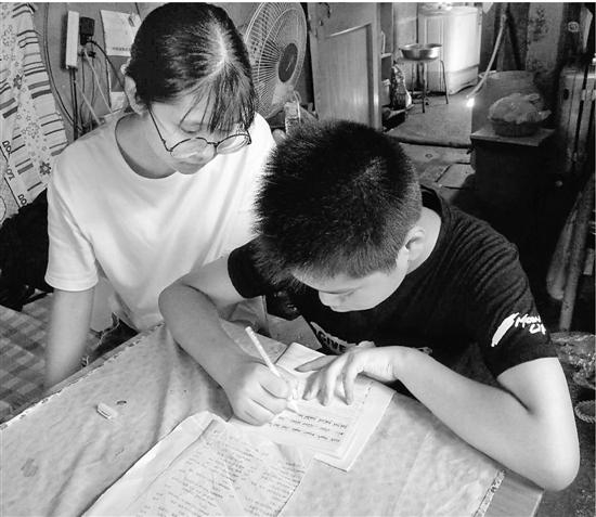 张丽莹辅导弟弟做作业。