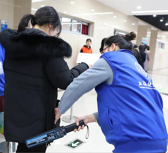 上海健康医学院春招校测平稳有序，考务人员正细致地对考生进行安检。何思哲 图