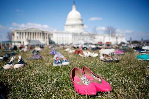 资料图：2018年3月，民众将多年里枪击事件中遇难儿童的鞋子摆放在华盛顿国会山前的草坪上，抗议国会面对枪击频发现状的不作为。（图片
  <div class=