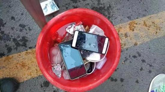 用于销毁手机的盛满水的水桶。 范亭中学官网 图