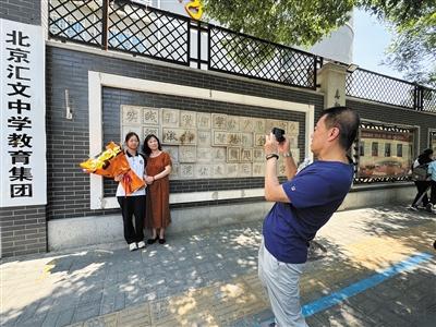 6月26日，文汇中学考点，黄同学与家人在考点门口拍照留念。新京报记者 徐彦琳 摄