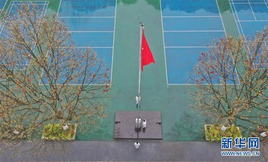 　　3月16日，贵阳市第六中学国旗班学生在操场上升旗，其余同学则在教室内参加升旗仪式。新华社记者 欧东衢 摄