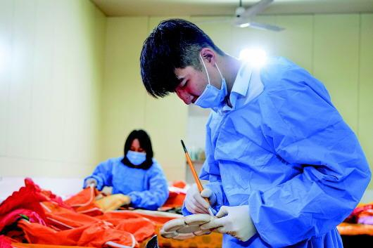 ▲王旭正在殡仪馆整容室给逝者整理仪容。本报记者屈彦摄